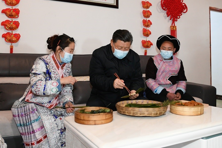 2021年2月3日下午，習(xí)近平在貴州畢節(jié)市黔西縣新仁苗族鄉(xiāng)化屋村苗族村民趙玉學(xué)家，同一家人邊聊家常邊制作當(dāng)?shù)貍鹘y(tǒng)節(jié)日食品黃粑。新華社記者 李學(xué)仁 攝