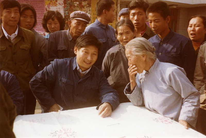 1983年，時(shí)任河北正定縣委書(shū)記的習(xí)近平（前排居中），臨時(shí)在大街上擺桌子聽(tīng)取老百姓意見(jiàn)。